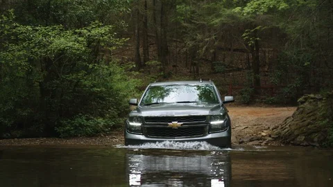 Chevy Suburban drives through water Stock Footage