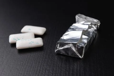 Chewing gum on the table. Mint refreshing tablet in a silver package. Stock Photos