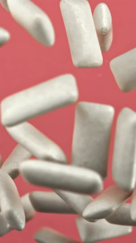Chewing gums fly on a pink background. Filmed on a high-speed camera at 1000 fps Stock Footage 335382327