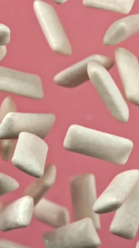 Chewing gums fly on a pink background. Filmed on a high-speed camera at 1000 fps Stock Footage 335384060