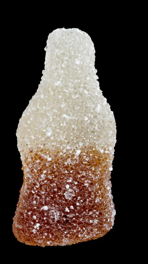 A chewy gummy candy in the shape of a cola bottle, dusted with sugar. It rotates 스톡 동영상 249603851