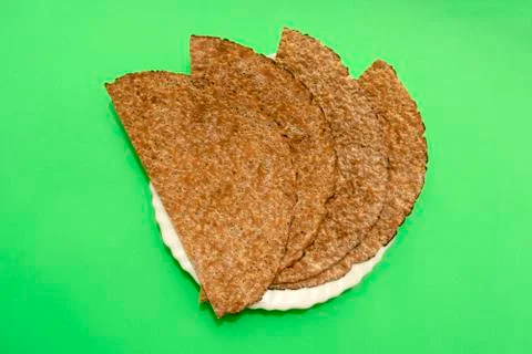 Chia flat bread in white plate on green background. Flat lay, top view. Stock Photos