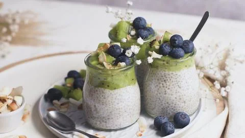 Chia pudding jars layered with kiwi and fresh blueberries Stock Photos