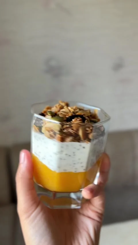 Chia pudding layered with mango puree, Greek yogurt and homemade granola in the Stock Footage 346688229