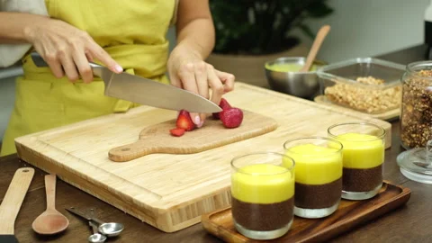 Chia pudding making process. Woman cut strawberry on wooden board Stock Footage 137945013