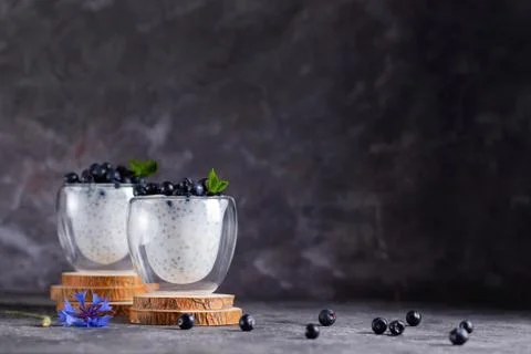 Chia pudding with mint and blueberries in glasses on a wooden stand Foto stock