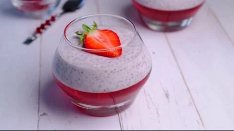 Chia seed pudding with berries in a jar on a wooden table. Stock Footage 155700116