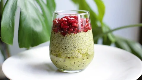 Chia seed pudding with coconut milk, matcha tea, kiwi and pomegranate Stock Footage 128565308
