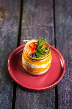 Chia Seed Pudding with Mango and Berries in Glass Jar on Red Plate Stock Photos