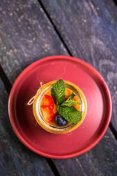 Chia Seed Pudding with Mango and Berries in Glass Jar on Red Plate Foto stock