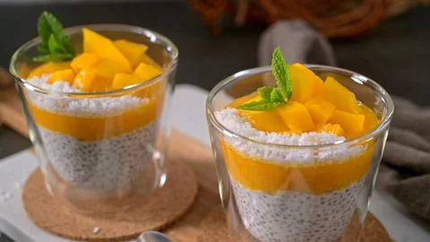 Chia seed pudding with mango and coconut in glass cups Stock Photos