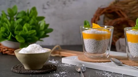 Chia seed pudding with mango puree and coconut flakes served in glass cups Stock Photos