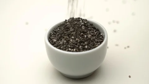 Chia seeds being filled into small white cup Stock Footage