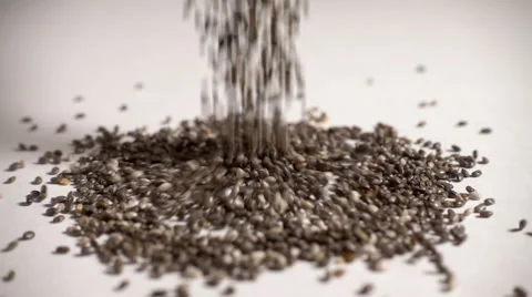 Chia seeds falling in slow motion onto white table Stock Footage 61694338