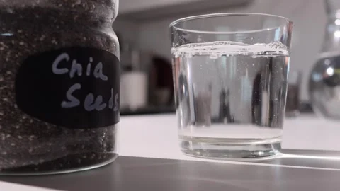 Chia Seeds Gel Formation in Water on Kitchen Counter Demonstrating High Fiber Stock Footage 346309136
