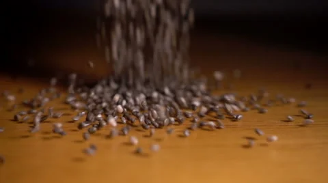 Chia seeds pour onto table, slow motion Stock Footage 61001501