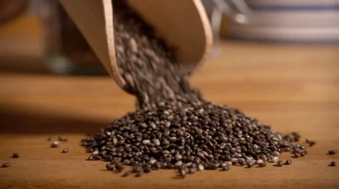 Chia seeds poured onto table, slow motion Stock Footage 61693993