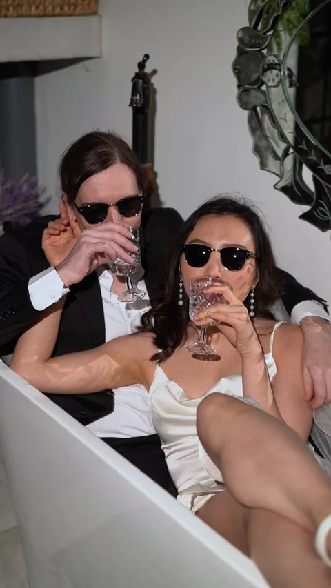 Chic Couple Sitting Together and Enjoying Drinks in a Beautiful Modern Bath Vidéo 291630647