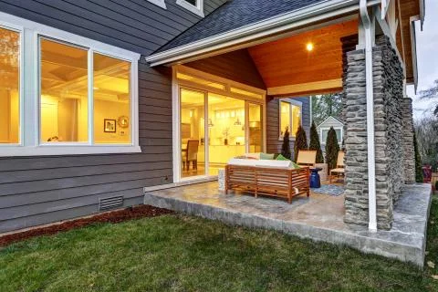 Chic covered back patio with built in gas fireplace, stone pillars, plank vau Stock Photos