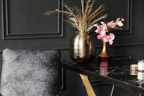 Chic dark interior featuring a stylish black marble table with gold accents Stock Photos