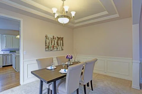 Chic dining room with light grey walls accented with wall panel mouldings und Stock Photos
