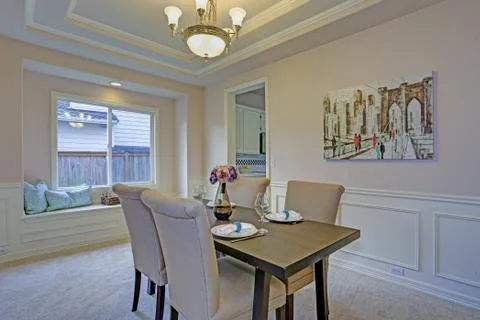 Chic dining room with light grey walls accented with wall panel mouldings und Stock Photos