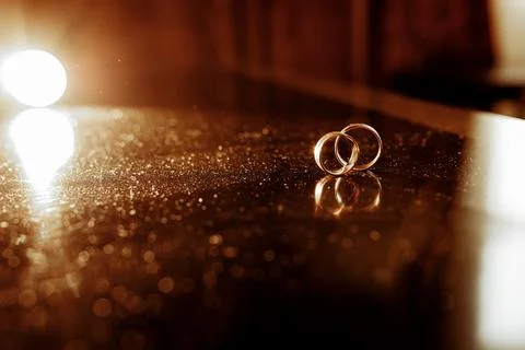 Chic gold rings close-up on the table of the newlyweds Stock Photos