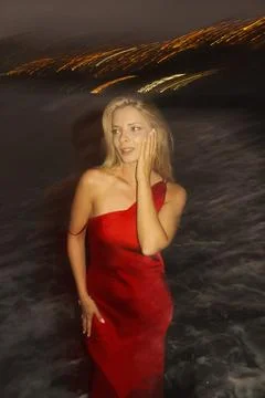 Chic model captures allure beside shimmering coastal skyline Stock Photos
