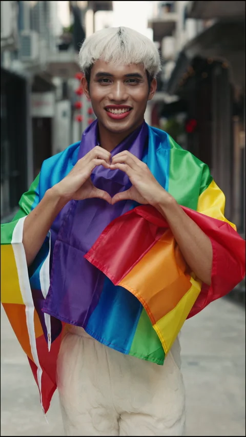 Chic Non-Binary Activist Standing Outdoors with LGBT Flag, Expressing Love with Stock Footage 275820354