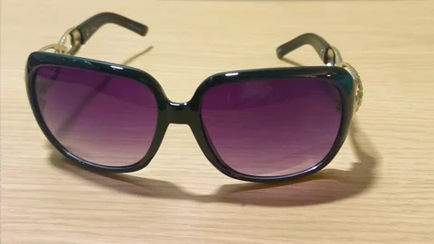 Chic oversized sunglasses with gradient purple lenses and gold embellishments, Video stock 318610870