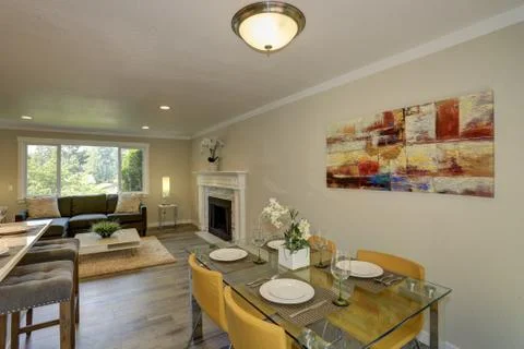 Chic small dining space design with glass-top dining table and yellow leather Stock Photos