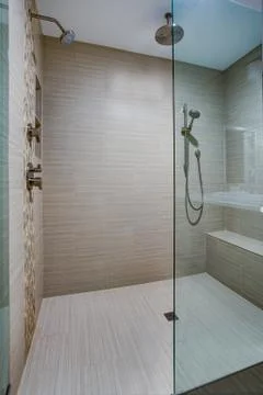 Chic Walk-in shower with built-in bench and beige subway tiled interior accen Stock Photos