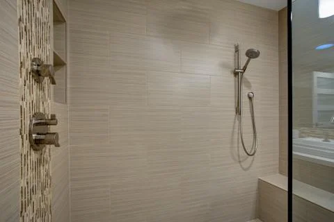 Chic Walk-in shower with built-in bench and beige subway tiled interior accen Stock Photos