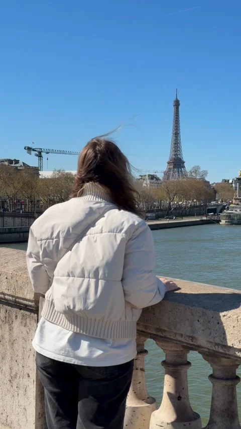 Chic woman adjusts posture while taking picture of Paris landmark Stock Footage 346672197