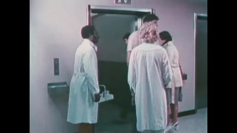 CHICAGO - 1970s - The patients board an elevator with two doctors. The patient Stock Footage 340587084