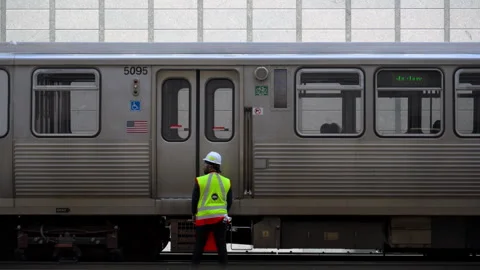 Chicago CTA train moving on railway tracks with transit worker in safety vest Stock Footage 334050222