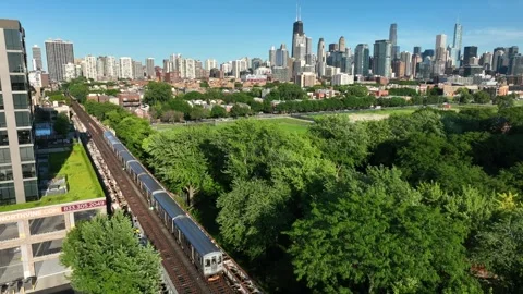 Chicago elevated train traveling on tracks in suburb during summer. Aerial 스톡 동영상 249811945
