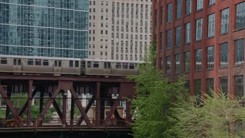 Chicago L train crossing an elevated railway bridge with classic and modern urba Stock Footage 337398777