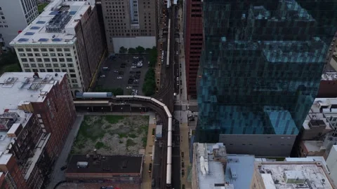 Chicago L train traveling through urban canyon of Loop neighborhood on elevated Stock Footage 337897513