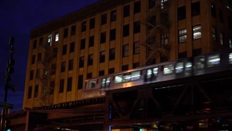 Chicago loop train passing by downtown apartment building at night on overhea Stock Photos