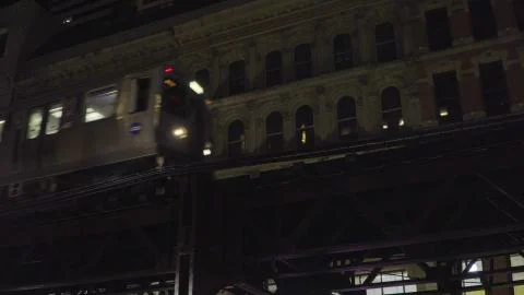 Chicago loop train passing by downtown apartment building at night on overhea Stock Photos