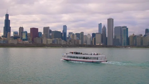 Chicago skyline during a cloudy sunrise and a ferry boat driving into port Stock Footage