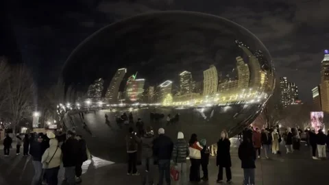The Chicago Skyline reflected in the Cloud Gate or "The Bean" with tourists Stock Footage 324948628
