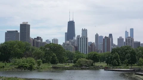 Chicago skyline reflection and people walking on boardwalks in Lincoln Park Stock Footage 340349171