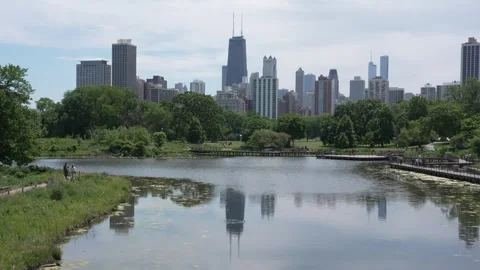 Chicago skyline reflection and people walking on boardwalks in Lincoln Park Stock Footage 340349236