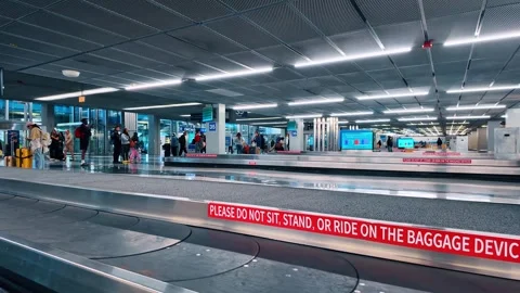 Chicago, USA, 7 May 2026: Baggage claim carousel with warning signs in airport, Stock Footage 336338995