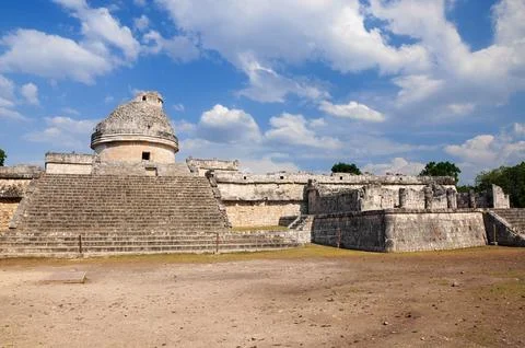Chichen Itza ruins under vibrant blue sky with fluffy clouds in Mexico Stock Photos