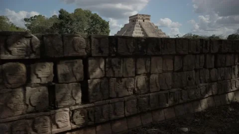 Chichen Itza Tzompantli the Wall of Skulls with pyramid in the distance. Stock Footage 160559305