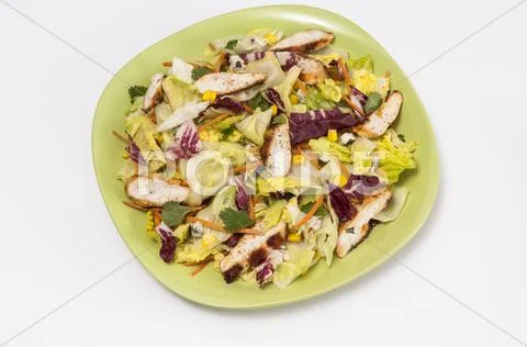 Chicken and sweetcorn salad on a green plate Stock Photos