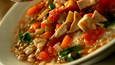 Chicken and vegetable soup plated in slow motion Video stock 120462063
